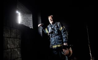 Brandmand står ved sodsværtet væg i nedbrændt hus